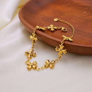 Detailed close-up of golden cross link bracelet on white silk with lobster clasp