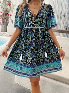 Close-up of ethnic floral paisley print and tassel neckline on V-neck summer dress