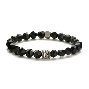 Détail macro des perles d'onyx facettées et pierres de carte sur un bracelet homme en inox