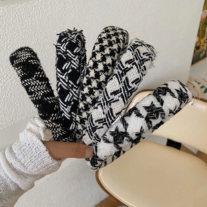 Close-up of five knitted checkered headbands featuring classic houndstooth patterns