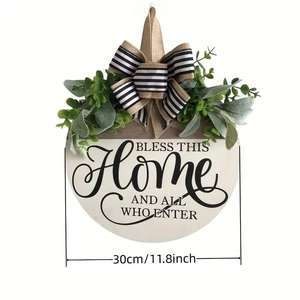 Detail of wooden home sign with 30cm diameter, green leaves and black-white striped bow