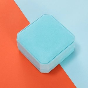 Octagonal light blue velvet jewelry box shown in a high-contrast diagonal composition