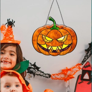 Detailed view of Halloween pumpkin lantern decoration with metal chain on a white wall