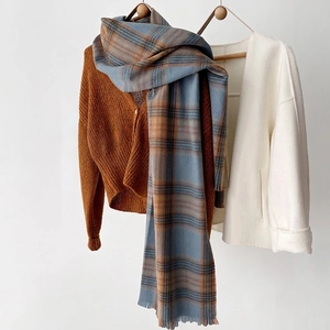 Plaid cashmere-feel winter scarf in blue and orange styled with a warm brown cardigan