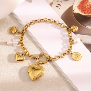 Detail showing 18K gold-plated charm bracelet with heart locket, pearls and T-bar clasp