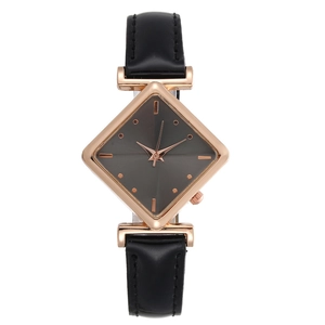 Macro shot of a minimalist diamond-shaped rose gold watch case with a sleek black leather band