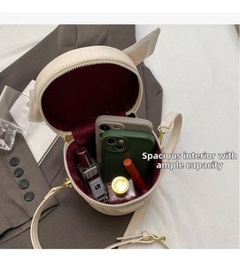Spacious interior of beige cylindrical bucket bag showing storage for phones and makeup
