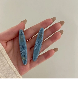 Détail de barrettes en acétate bleu marbré avec lettrage doré France Handmade