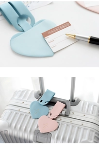 Detail of heart-shaped faux leather luggage tags in blue and pink with info cards