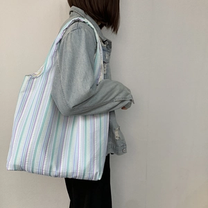 Vue détaillée du grand sac cabas en toile rayée montrant la texture et la grande capacité