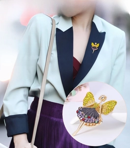 Detail of golden elf brooch with yellow rhinestones on mint green suit jacket