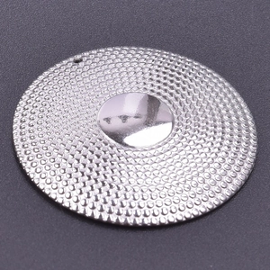 Close-up of a round stainless steel pendant with embossed texture and polished center