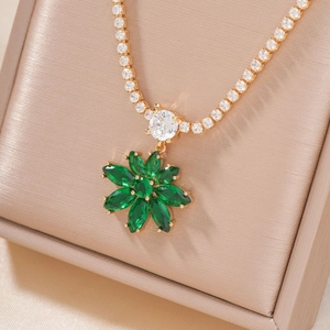Élégant collier à fleurs dorées avec zircons verts et clairs sur support en soie