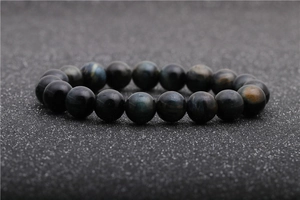 Macro shot of natural blue tiger eye stone beads on a dark textured background
