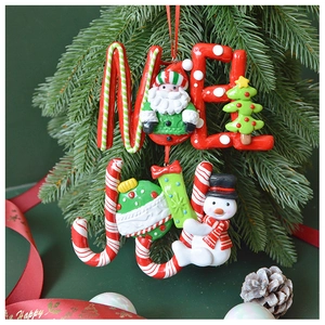 Detail of Christmas polymer clay ornaments with Merry and Joy text on pine branch