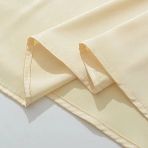 Gros plan détaillé du tissu en dentelle beige avec coutures de finition professionnelles