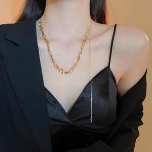 Collana con frange a foglia di grano dorata e catena lunga indossata da modella