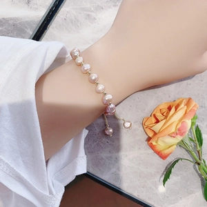 Close-up of baroque natural pearl bracelet with gold beads and adjustable drawstring