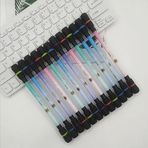 Detail view of 12 constellation spinning pens arranged on a white keyboard for balance