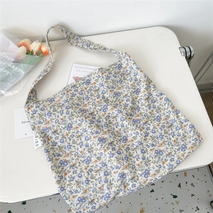 Detail of floral canvas tote bag showing blue orange pattern and MISS label close-up