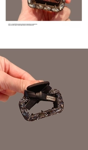Detail of premium black leather bow hair claw with rhinestones and metal nameplate
