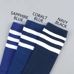 Flat lay of royal and navy blue knee-high socks with three white athletic stripes