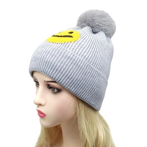 Graue Strickmütze mit großem Bommel und gelbem Smiley-Gesicht für warme Wintertage