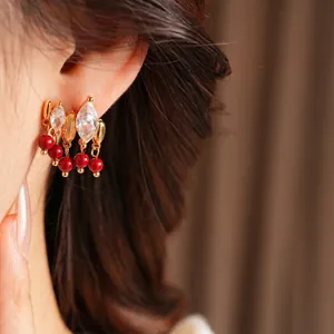 18K gold plated flower earrings with red beads and marquise zircon on model