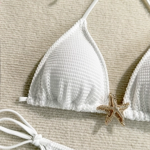Detail of white waffle texture bikini top with a gold rhinestone starfish embellishment