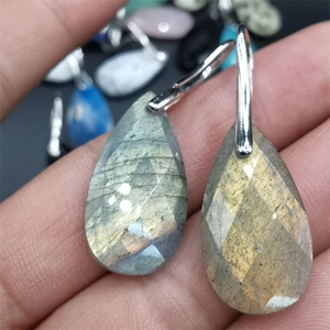 Macro shot of faceted labradorite teardrop earrings showing blue and yellow iridescence