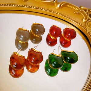 Lot de quatre boucles d'oreilles en résine ambrée avec élégante bordure en métal doré