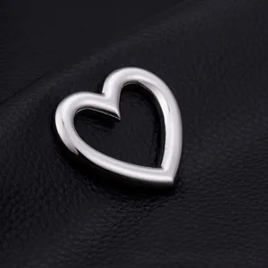 Polished hollow heart stainless steel pendant on black leather background