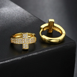 Close-up of golden cross hoop earrings with micro-paved zircons on black background
