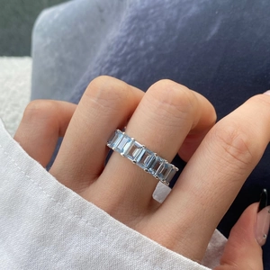 Close-up of S925 sterling silver ring with emerald-cut blue zircons on a model finger