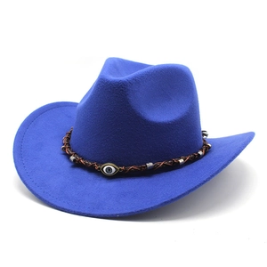 Detailed macro view of bright blue felt cowboy hat with woven band and evil eye charm