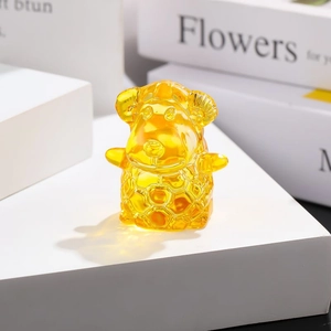 Amber glass sheep zodiac ornament with intricate scale textures on a white pedestal