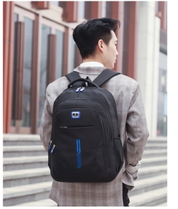 Outdoor shot of man wearing a black large capacity nylon backpack with blue zipper details