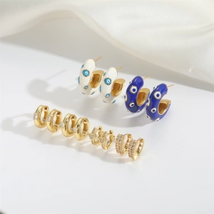 Set of gold-plated hoop earrings with evil eye enamel patterns and crystal heart designs