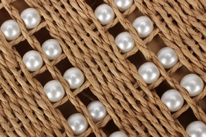 Vue détaillée du tissage artisanal en corde de papier orné de perles blanches