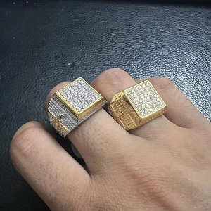 Close-up of gold and silver iced out square hip hop rings with micro pave diamonds
