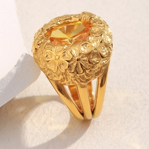 Close-up of 18K gold flower ring featuring a large yellow oval zircon and floral relief