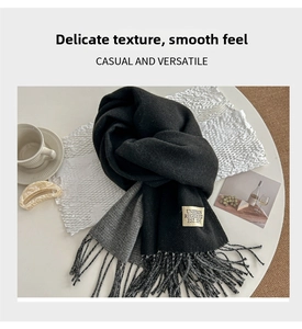 Detailed view of bicolor knit scarf with fringe edge and vintage woven label detail