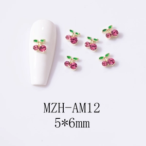 Macro detail of 5x6mm pink cherry nail charms with green leaves and gold alloy base