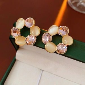 Orecchini vintage a corona dorati con cristalli rosa in un portagioie verde scuro