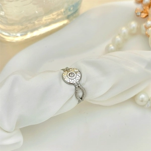 Vintage silver sunburst star ring with zircon stone on elegant white silk fabric