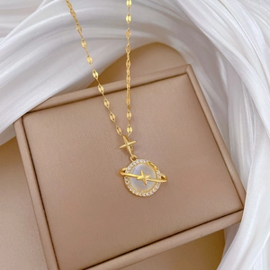 Detailed close-up of golden planet necklace with white cat eye stone and cubic zirconia stars