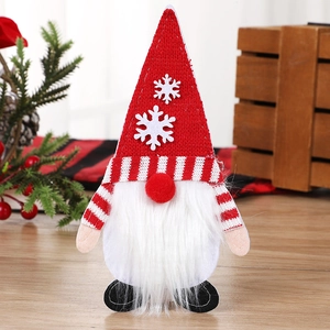 Portaposate a forma di gnomo di Natale con cappello rosso e barba su tavolo in legno