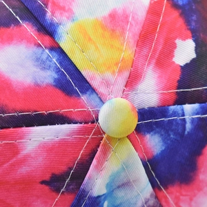 Detail of starry sky gradient baseball cap with tie-dye patterns and white stitching