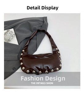 Close-up of silver studs on dark brown crescent bag with glossy faux leather texture