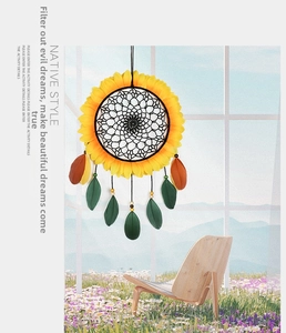 Detailed close-up of yellow sunflower dreamcatcher with green and brown feathers